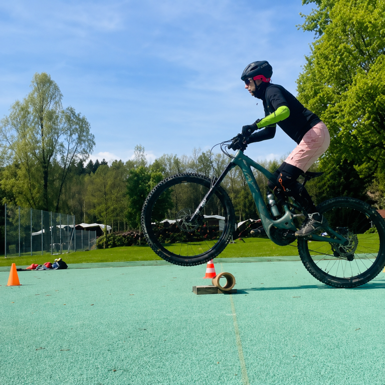 Mountainbikerin trainiert das Überfahren von Wurzeln und kleinen Steinstufen am Samerberg